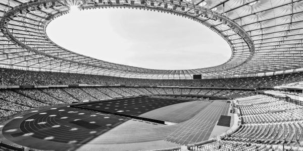 rows of yellow and blue stadium seats on soccer field stadium, black and white